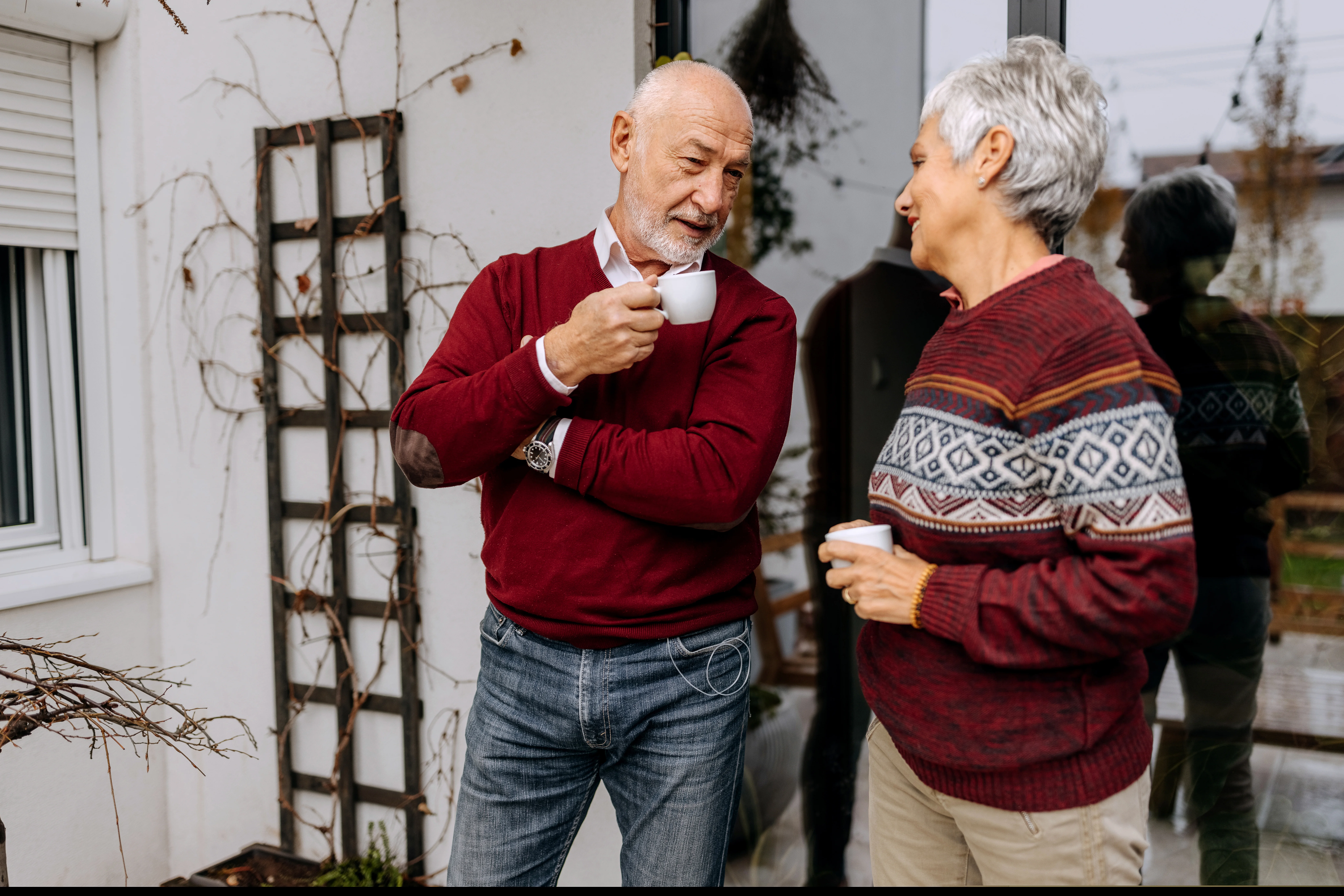 Een man en een vrouw houden bekers vast terwijl ze praten